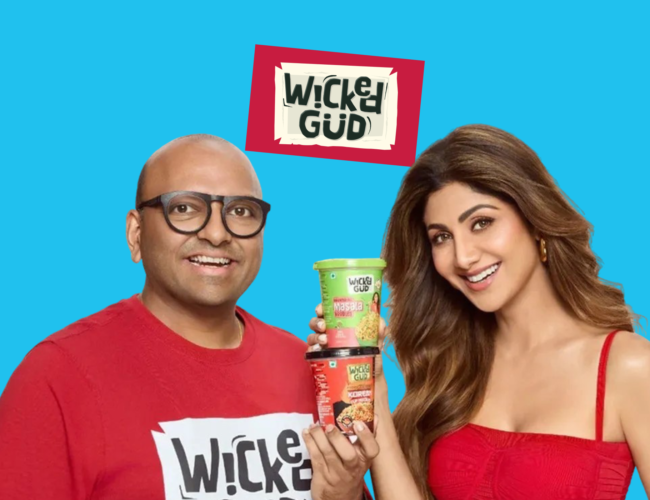 WickedGud promotional graphic featuring fopunder Bhuman Dani and actress Shilpa Shetty holding two cups of WickedGud instant noodles against a light blue background.