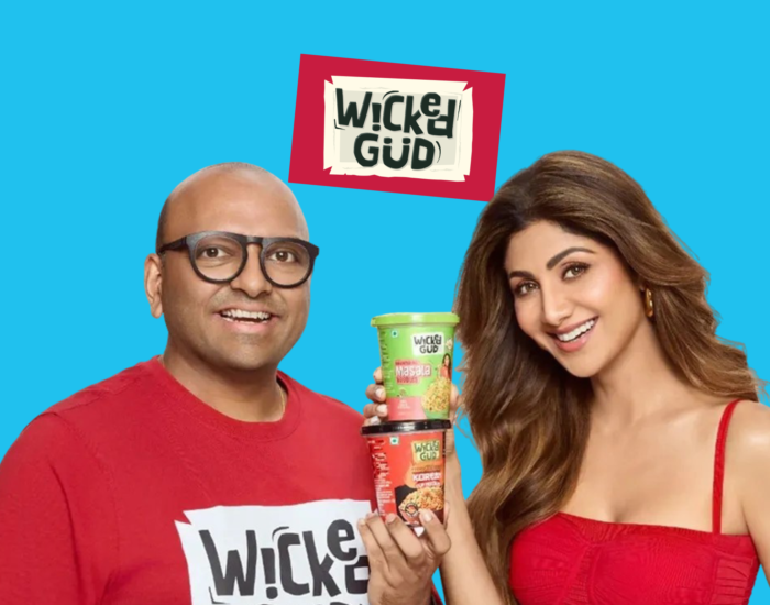 WickedGud promotional graphic featuring fopunder Bhuman Dani and actress Shilpa Shetty holding two cups of WickedGud instant noodles against a light blue background.